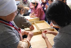 お餅を丸めている参加者