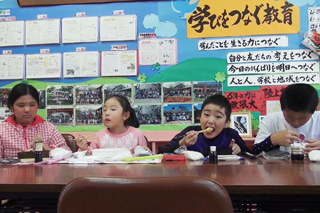 お腹いっぱい餅を食べる児童