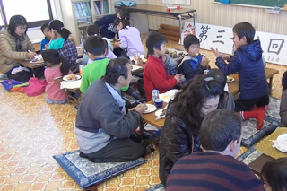 餅を食べ笑顔を見せる子どもたち