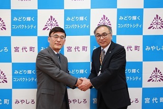 町長と握手する塩崎さん