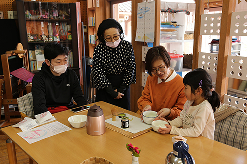 体験をする若い子連れの夫婦