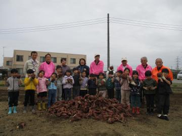 交流みやしろさんと一緒に集合写真を撮る5歳児クラスのこどもたち。